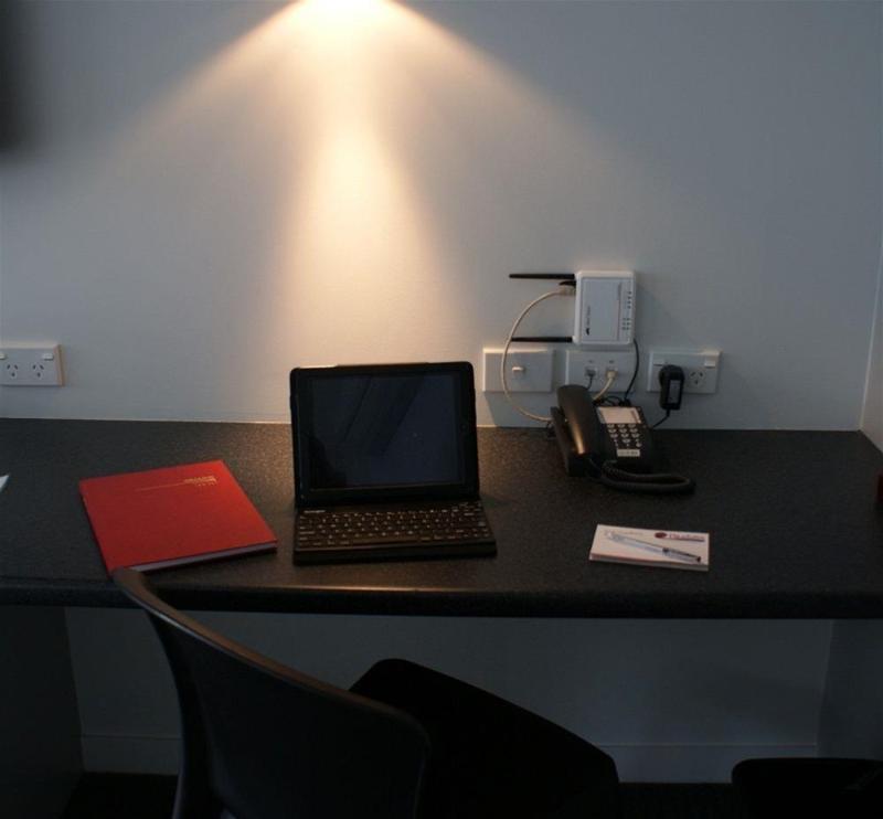 Pukekura Motor Lodge New Plymouth Exteriér fotografie A typical hotel room with a phone, a laptop and a book